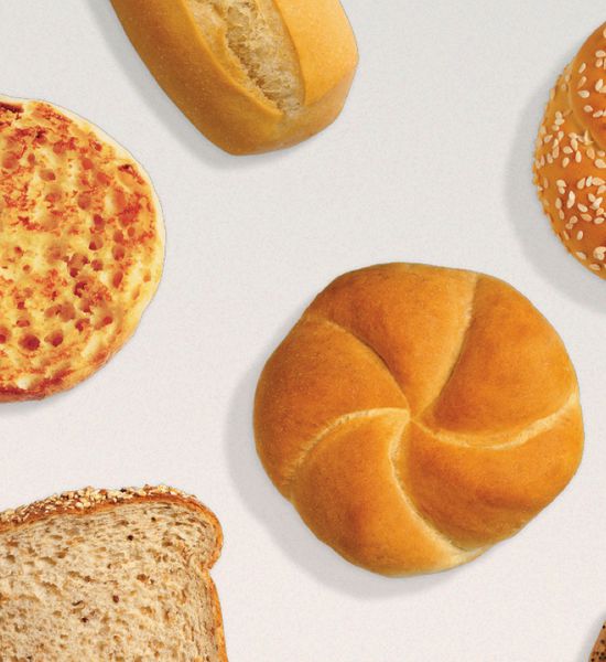 Freshly baked rye bread, english muffin, wheat bread, sesame seeds bun on a table.